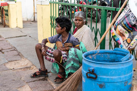 Mysuru, Karnataka, India - January 2018: An elderly Indian female sanitation worker sitting with a young boy on the streets of the city of Mysore.のeditorial素材