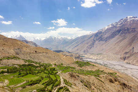 Beautiful landscape of Himalayan mountains above the green fields of the village of Dhankar in the Spiti valley in Himachal Pradesh, India.の写真素材