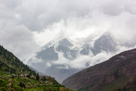 Beautiful Himalayan landscape of isty clouds around snow capped mountains in the town of Keylong in the Lahaul district in Himachal Pradesh, India.の写真素材