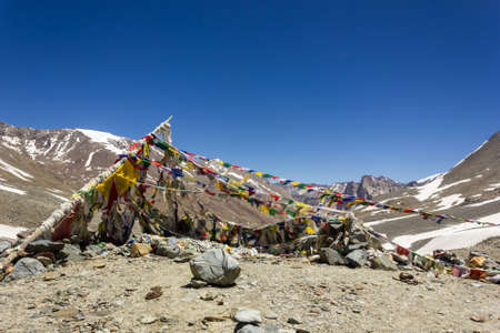 Zanskar, India - July 2012: Colorful tibetan Buddhist prayer flags on top of the high altitude pass of Shingo La over the Great Himalayan range in Zanskar.のeditorial素材