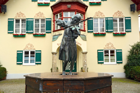 Sculpture of young Mozart playing the violin in front of the Town Hall. Alpine village Sankt-Gilgen, Austria.のeditorial素材