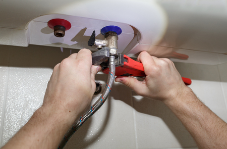 Water heater repair: turning soft iron pipes with pipe wrenchの写真素材