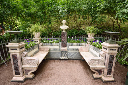 PETERHOF, RUSSIA - JULY 2, 2017. Memorial bench with a sculpture bust of the Grand Duchess Alexandra Nikolaevna of Russia in the lower gardens of the Petergof palace near Saint Petersburg, Russia.のeditorial素材