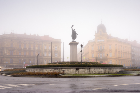 ZNOJMO, CZECH REPUBLIC - DECEMBER 27, 2017. Ivan Victory Memorial - sculpure of a Red Army soldier called Ivan with a machine gun in his hand on a foggy winter day. Znojmo, Czech Republic.のeditorial素材