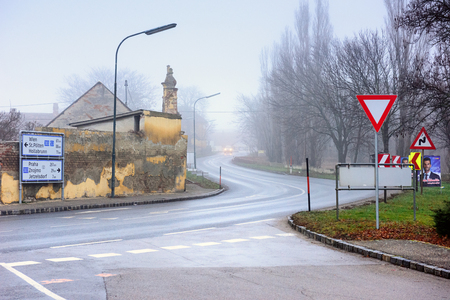 GUNTERSDORF, AUSTRIA - DECEMBER 28, 2017. Vehicles moving on a winding country road through historical town on a foggy winter day. Town of Guntersdorf, district of Hollabrunn, Lower Austria, Europeのeditorial素材