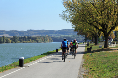 Group of people riding bicycles along the Danube river on the famous cycling route Donauradweg. Town of Ybbs an der Donau, Lower Austria, Europe.の写真素材