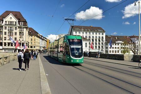 BASEL, SWITZERLAND - APRIL 17, 2019. Green tram on the bridge Mittlere Bruecke. City of Basel,...