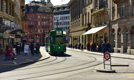 BASEL, SWITZERLAND - APRIL 17, 2019. Green tram driving through the historic center Grossbasel. City...