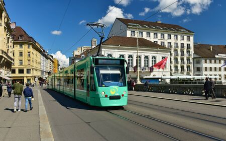 BASEL, SWITZERLAND - APRIL 17, 2019. Green tram on the bridge Mittlere Bruecke. City of Basel, Switzerland, Europeのeditorial素材