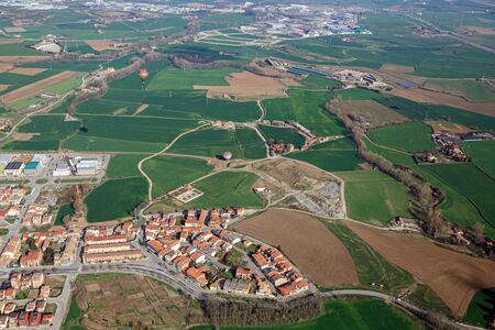 View from hot air balloon towards the village Calldetenes - suburb of town of Vic. Agricultural landscape in spring. Province of Barcelona, Catalonia, Spain.の写真素材