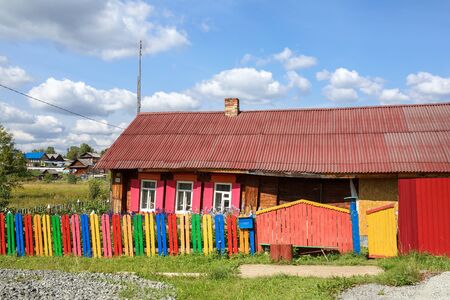 Village street. Brightly painted rickety wooden house. Village of Visim, Sverdlovsk region, Urals, Russiaの写真素材