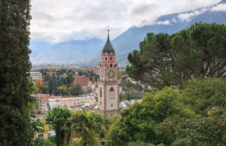 Saint Nicholas Church on the background of Alps in autumn. Merano, Italy.