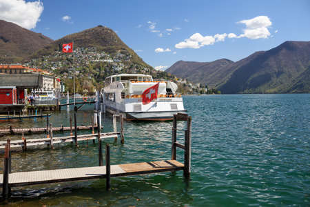 LUGANO, SWITZERLAND - APRIL 17, 2018. City of Lugano at the lake Lugano, surrounded by Alps. View of the pleasure craft at the pier. Lugano, canton of Ticino, Switzerland, Europe.のeditorial素材