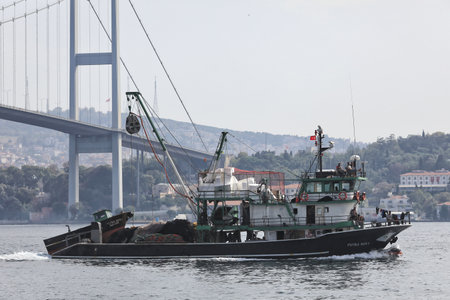 ISTANBUL, TURKEY - OCTOBER 06, 2020. Fishing vessel in front of the Bosphorus Bridge in the Bosphorus Strait. City of Istanbul, Turkey.のeditorial素材
