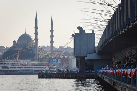 ISTANBUL, TURKEY - OCTOBER 06, 2020. Galata Bridge on the Golden Horn, with the New Valide Sultan Mosque in the background. View of many fishing rods installed on bridge. City of Istanbul, Turkey.のeditorial素材