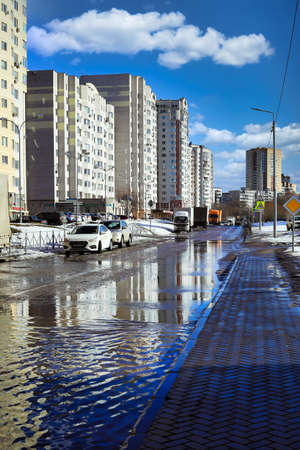 BALASHIKHA, RUSSIA - MARCH 19, 2021. Flooded road in a residential area in the spring. Snow melting. City of Balashikha, Moscow region, Russia.のeditorial素材