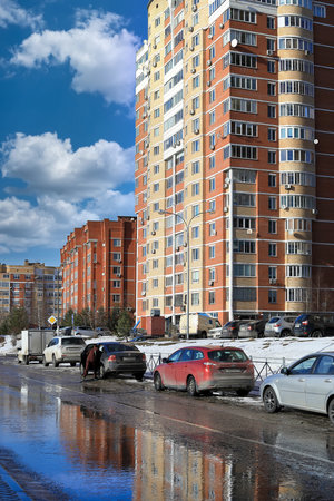 BALASHIKHA, RUSSIA - MARCH 19, 2021. Residential area on the spring sunny day. Snow melting on the road. Cars parked on the roadside. City of Balashikha, Moscow region, Russia.のeditorial素材