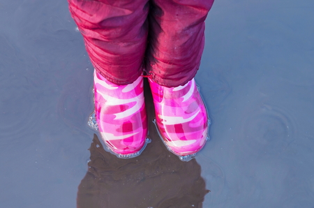 rubber boots in mud puddleの写真素材