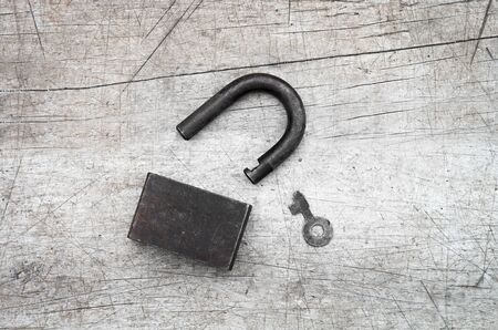 Open padlock and key on wooden background, retro toningの写真素材
