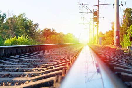 railway line and a traffic light against the backdrop of sunsetの写真素材