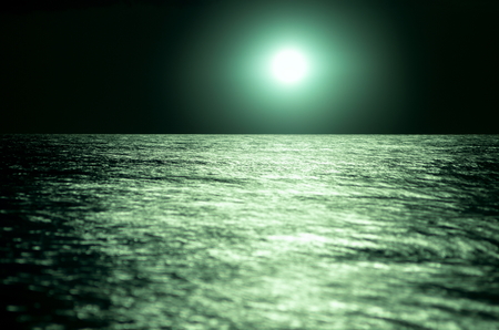 bright moon green over the sea at night. moonlight on the waves, horizon. Long exposure. Fantastic landscapeの写真素材