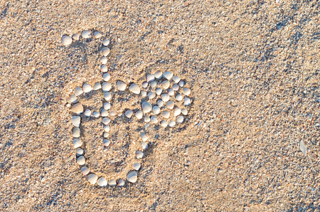 lined with seashells glass with a cocktail in the sand on the beachの写真素材