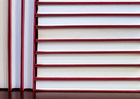 vertical and horizontal stacks of books in a red cover