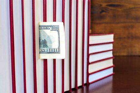 bookmark in the form of a dollar in one of the books in the rowの写真素材