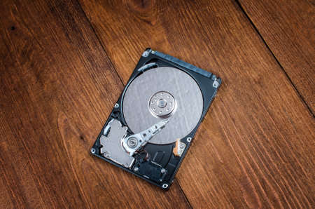 disassembled computer hard drive close-up on wooden background