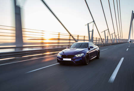 Business class black sedan driving on the bridge