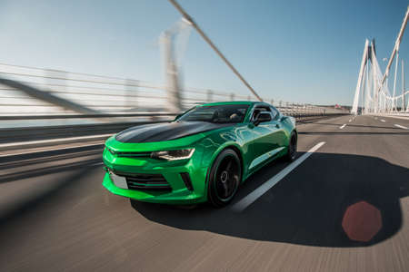 Green sport sedan driving on the bridge. front viewの写真素材