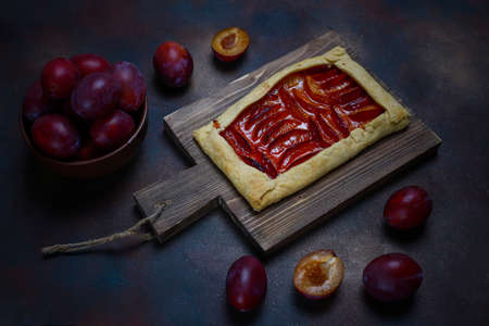 Fresh plum palette pie with raw plums on dark backgroundの写真素材