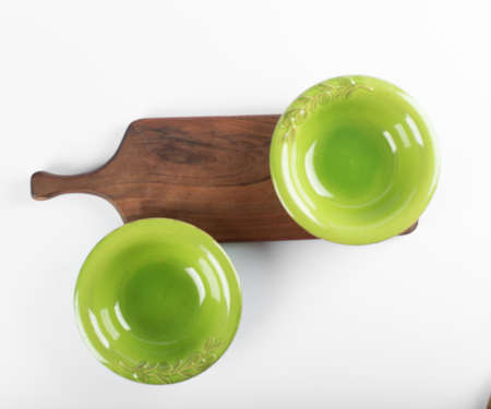 Green saucers on a wooden cutting boardの写真素材