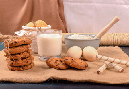 Cup of milk with cinnamon biscuits and flour