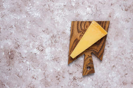 cheese board with hard cheese ,cheese knife,red wine glass,grape on brown concrete backgroundの写真素材