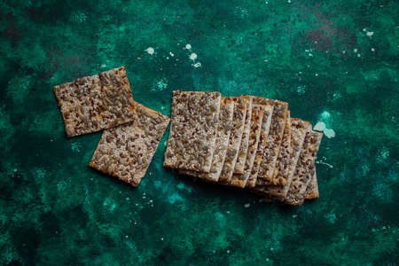 Assortment of salt crackers shot from the top on colorful background with copy space. Salty party...