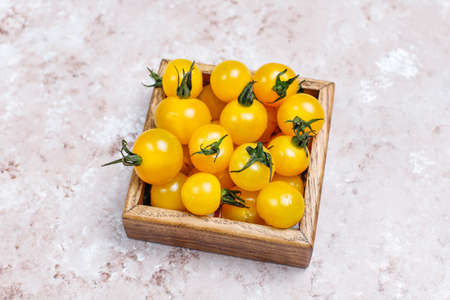 Arrangement of colorful fresh assorted tomatoes on light concrete background,top viewの写真素材