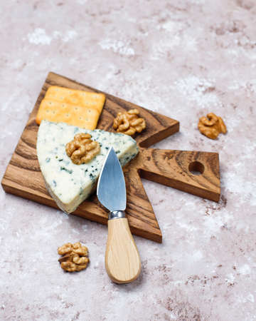 blue cheese on wooden cutting board with honey and walnuts