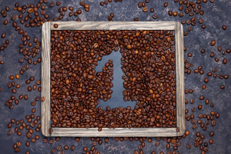 Composition with roasted coffee beans and coffee bean shaped cookies on dark brown backgroundの写真素材