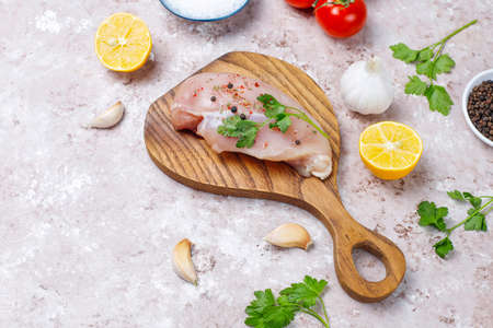Raw chicken breast fillets on wooden cutting board with herbs and spices.top viewの写真素材