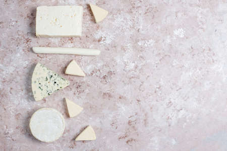 Various types of cheese on light brown background,top viewの写真素材