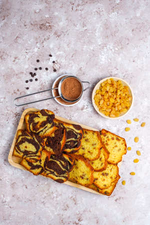 Traditional raisin marble cake slices with raisins and cocoa powder on light background,top viewの写真素材