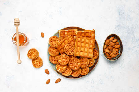 Traditional belgian waffles with fresh berries and honey on grey concrete background. Flat lay, top view, copy space.の写真素材