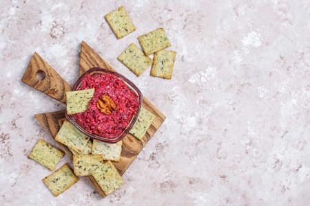 Beetroot hummus on cutting board with salty cookies on light backgroundの写真素材