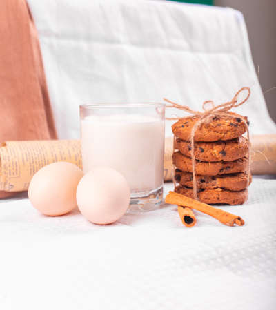 A glass of milk with caramel cookies and raw eggsの写真素材