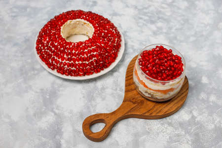Salad Garnet bracelet. Vegetable salad with pomegranate seeds with pomegranate on concrete backgroundの写真素材