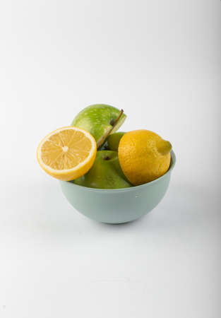 Lemon and apple pieces in a silver bowlの写真素材