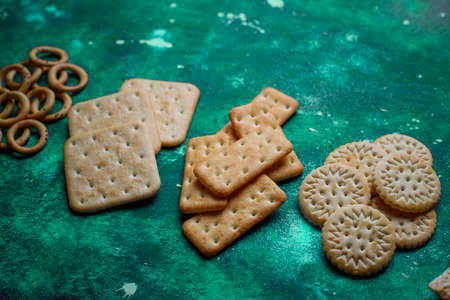 Assortment of salt crackers shot from the top on colorful background with copy space. Salty party...