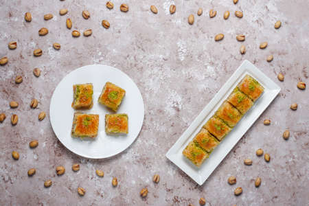 Traditional Turkish Pastry Dessert Baklava with pistachio nuts on concrete background.