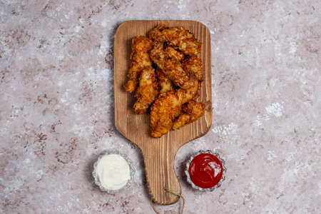Chicken strips with ketchup and mayonnaise. top view on brown light background.の写真素材
